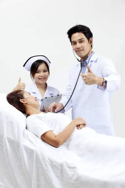 Retrato de un médico con sus compañeros de trabajo hablando con un paciente en el fondo —  Fotos de Stock