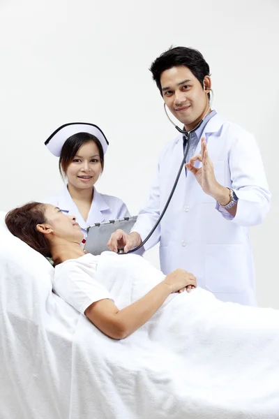 Retrato de um médico com seus colegas conversando com um paciente em segundo plano — Fotografia de Stock