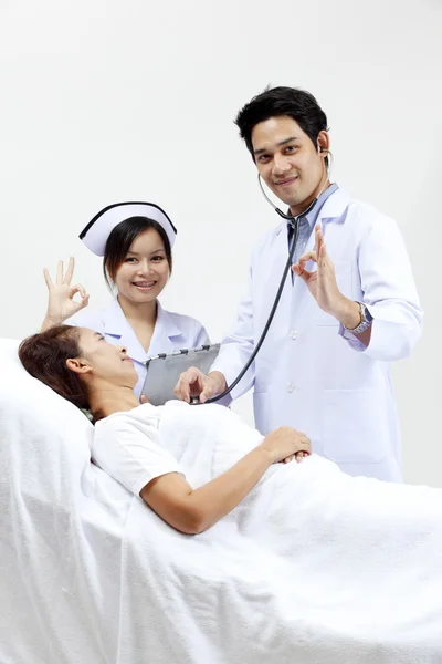 Retrato de un médico con sus compañeros de trabajo hablando con un paciente en el fondo —  Fotos de Stock