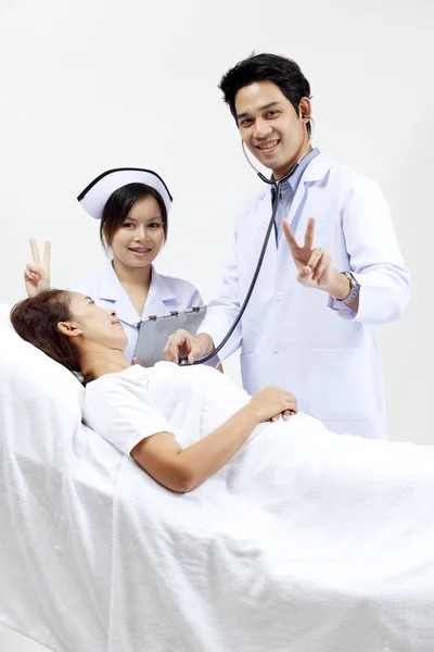医生与他的同事跟一个病人在背景中的肖像 — 图库照片