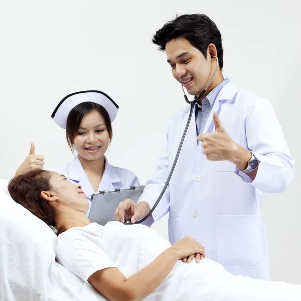 Retrato de um médico com seus colegas conversando com um paciente em segundo plano — Fotografia de Stock