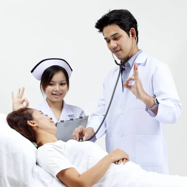Portrait of a doctor with his co-workers talking with a patient in the background — Stock Photo, Image