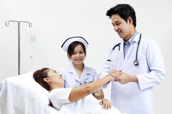 Retrato de un médico con sus compañeros de trabajo hablando con un paciente en el fondo —  Fotos de Stock