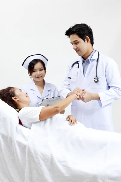 Retrato de un médico con sus compañeros de trabajo hablando con un paciente en el fondo —  Fotos de Stock