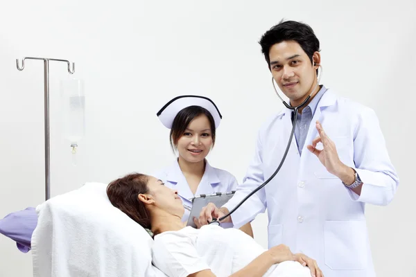 Retrato de um médico com seus colegas conversando com um paciente em segundo plano — Fotografia de Stock