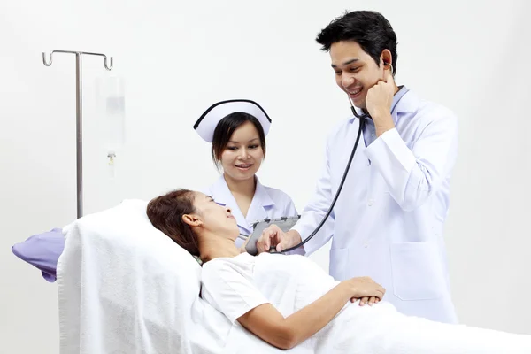 Retrato de un médico con sus compañeros de trabajo hablando con un paciente en el fondo —  Fotos de Stock