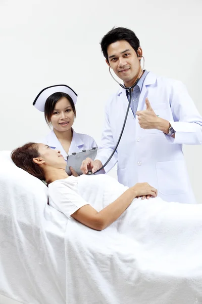 Porträt eines Arztes mit seinen Mitarbeitern im Gespräch mit einem Patienten im Hintergrund — Stockfoto
