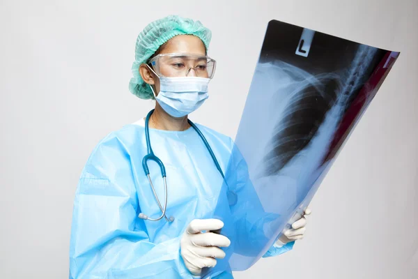Ung och trevlig läkare tittar på en patient röntgen på sjukhus — Stockfoto