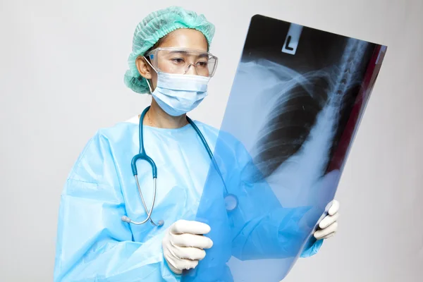 Médico joven y agradable observando una radiografía de paciente en el hospital — Foto de Stock