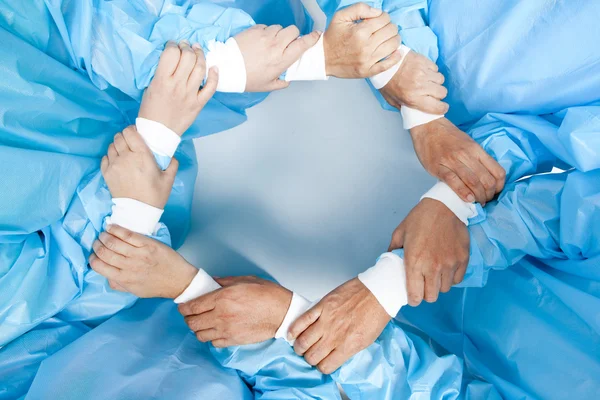 Small group of doctor team joining hands, bird's eyes angle view. — Stock Photo, Image
