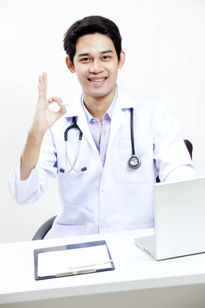 Retrato de um médico maduro confiante sentado em sua mesa de escritório — Fotografia de Stock