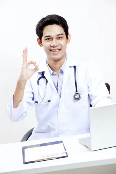 Porträt eines selbstbewussten reifen Arztes, der an seinem Schreibtisch sitzt — Stockfoto