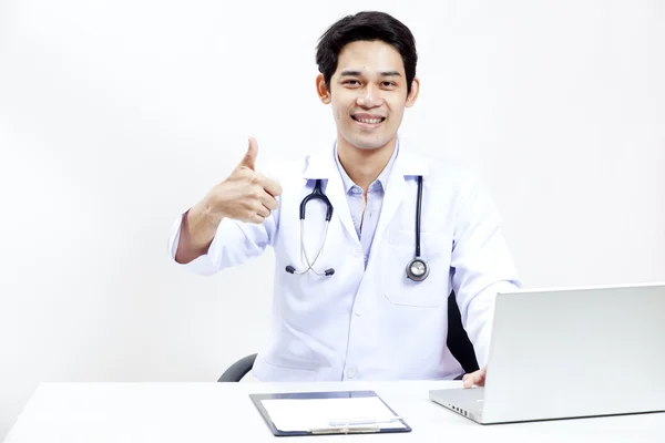 Porträt eines selbstbewussten reifen Arztes, der an seinem Schreibtisch sitzt — Stockfoto