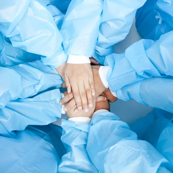 Pequeño grupo de equipo médico que une las manos, vista de ángulo de ojos de pájaro . Imagen de stock