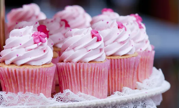 Närbild av en platta av läckra färgglada cupcakes på en vit platta — Stockfoto