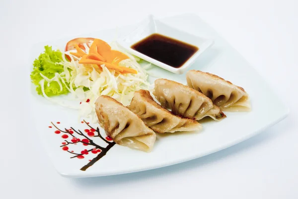 Dumplings de cerdo frito y camarones en un plato con salsa de soja y palillos —  Fotos de Stock