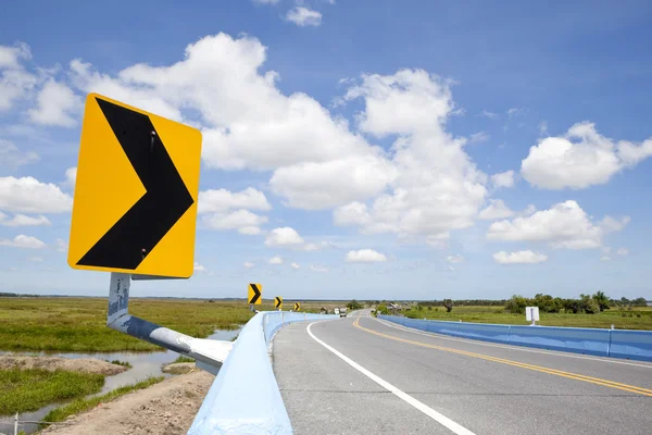 Gevaar kromme verkeersbord met blauwe hemel — Stockfoto