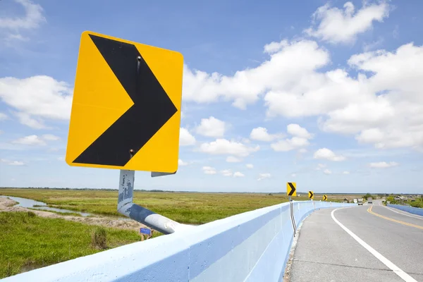 Nebezpečí křivka dopravní značka s modrou oblohou — Stock fotografie