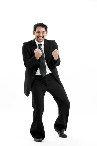 Portrait of an excited young man celebrating success with raised hand against white background — Stock Photo, Image