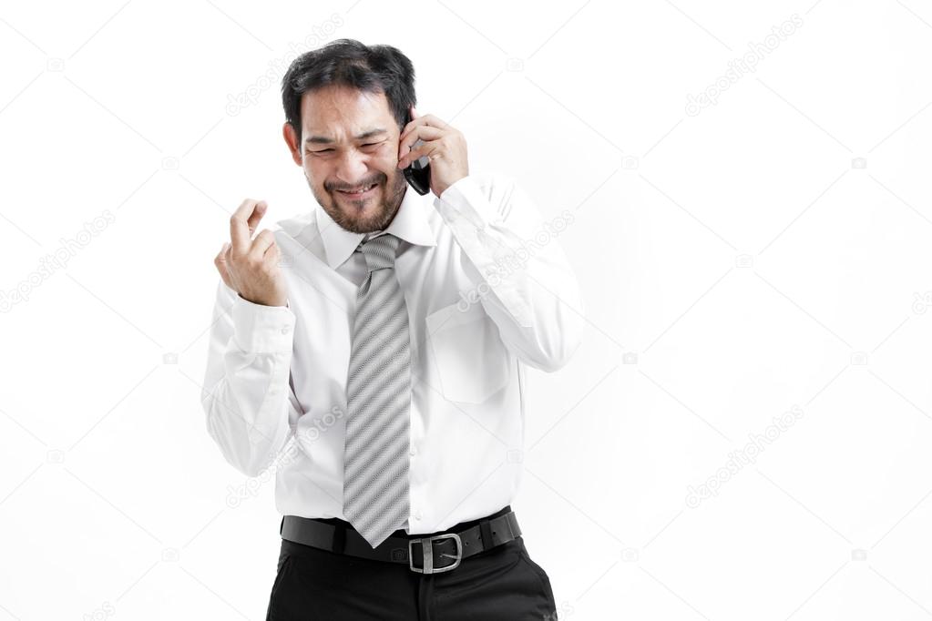 Superstitious - Asian business man with crossed fingers over white background
