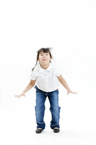 Портрет маленькой девочки в белой рубашке и синих джинсах, веселящихся на белом фоне — стоковое фото