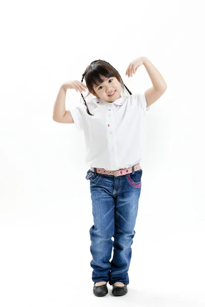 Retrato de niña con camisa blanca y vaqueros azules que se divierten en el fondo blanco —  Fotos de Stock