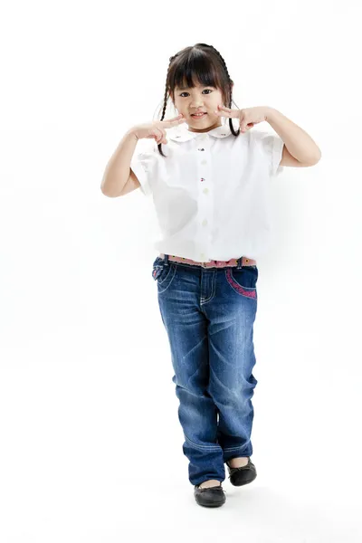 Retrato de niña con camisa blanca y vaqueros azules que se divierten en el fondo blanco —  Fotos de Stock