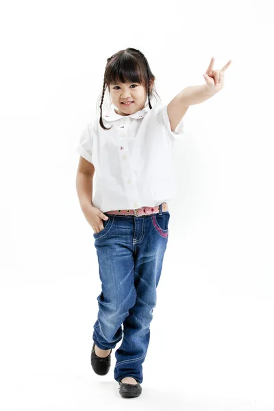 Retrato de niña con camisa blanca y vaqueros azules que se divierten en el fondo blanco —  Fotos de Stock