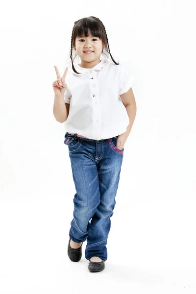 Портрет маленької дівчинки з білою сорочкою і блакитними джинсами розважається на білому тлі — стокове фото