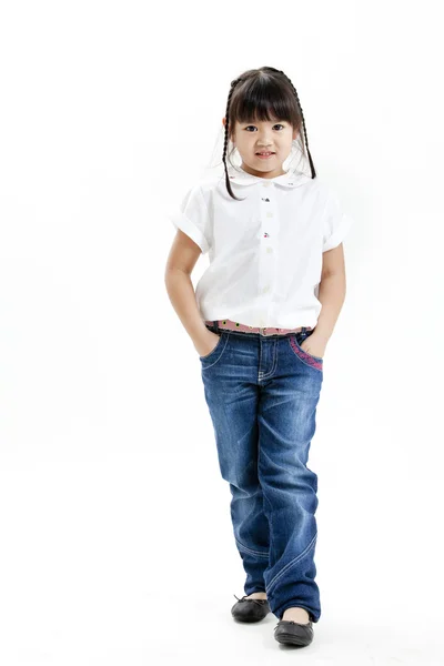 Портрет маленькой девочки в белой рубашке и синих джинсах на белом фоне — стоковое фото