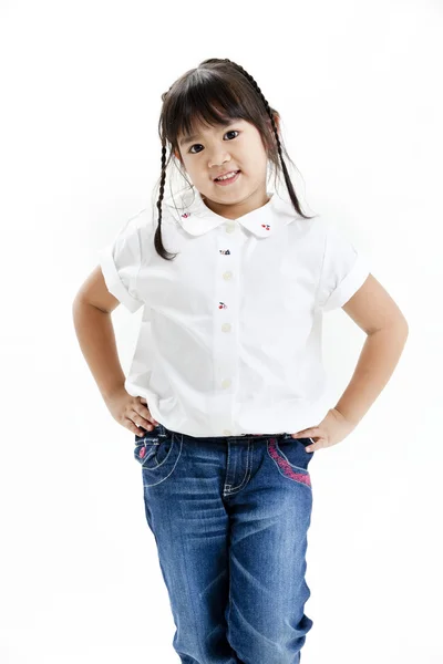 Malá dívka portrét s bílou košili a modré džíny na bílém pozadí — Stock fotografie