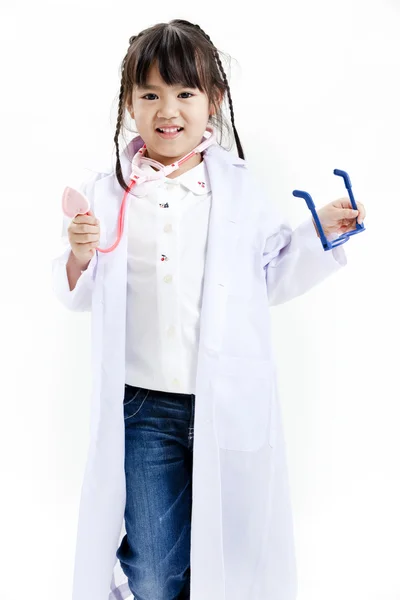 一个年轻的亚洲女孩开心装扮成医生作为一名医生 图库照片
