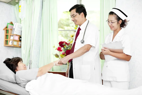 Médico e enfermeiro conversando com um paciente — Fotografia de Stock