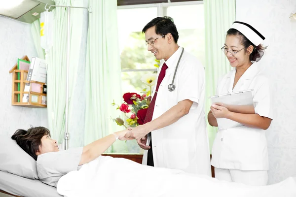 Médico y enfermera hablando con un paciente — Foto de Stock