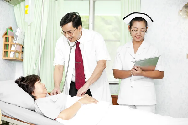 Médico e enfermeiro conversando com um paciente — Fotografia de Stock