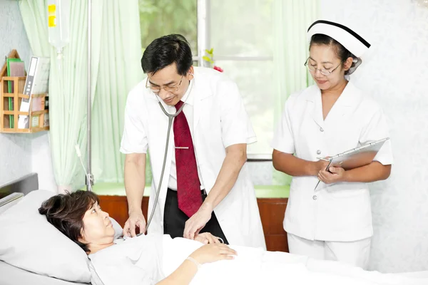 Médico e enfermeiro conversando com um paciente — Fotografia de Stock