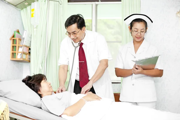 Médico y enfermera hablando con un paciente — Foto de Stock