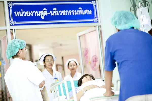 Dělník, přesun pacienta na nemocniční vozík na operační sál — Stock fotografie