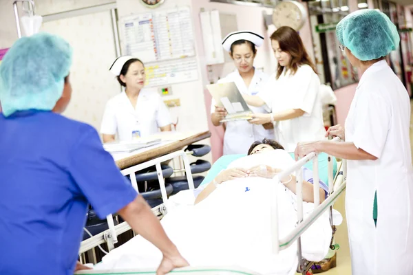Operaio che sposta il paziente sul carrello dell'ospedale in sala operatoria — Foto Stock
