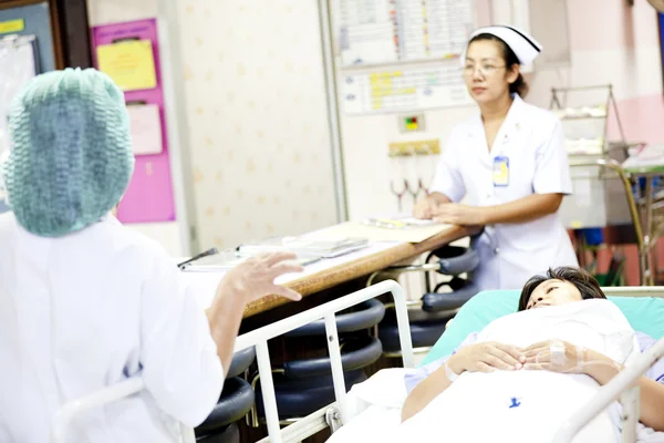 Trabajadores médicos con paciente en el carro del hospital —  Fotos de Stock