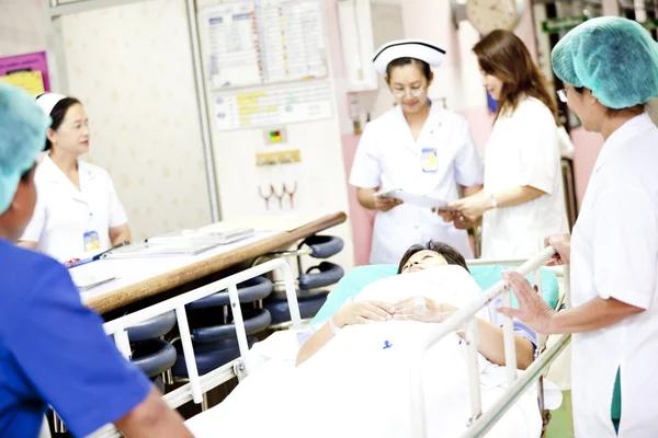 Worker moving patient on hospital trolley to operating room — Stock Photo, Image