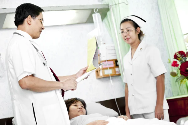 Médecin et infirmière parlant avec un patient — Photo