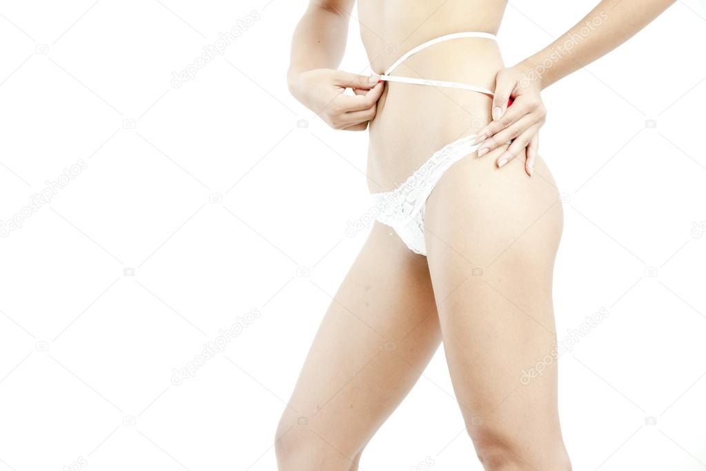 Sporty woman with slim body measuring body - model posing in studio