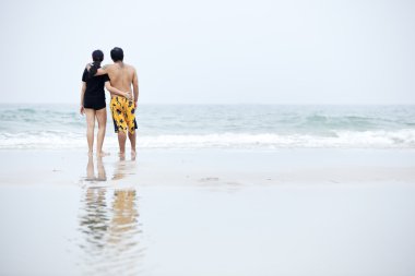 Kumsalda yürüyen çift