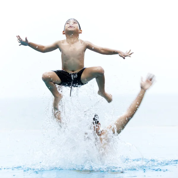 Jonge jongen springen in de zee — Stockfoto