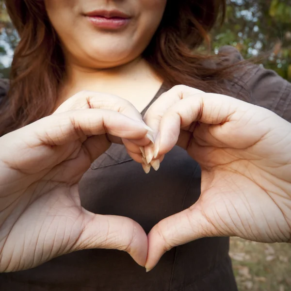 Corazón formado por manos femeninas — Foto de Stock