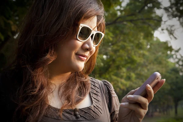 Portrait of a cheerful young woman using the cellphone — Stock Photo, Image