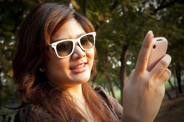 Portrait of a cheerful young woman using the cellphone — Stock Photo, Image