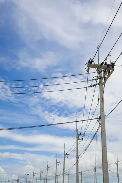 Power lines on the blue sky with cloudy background — Stock Photo, Image