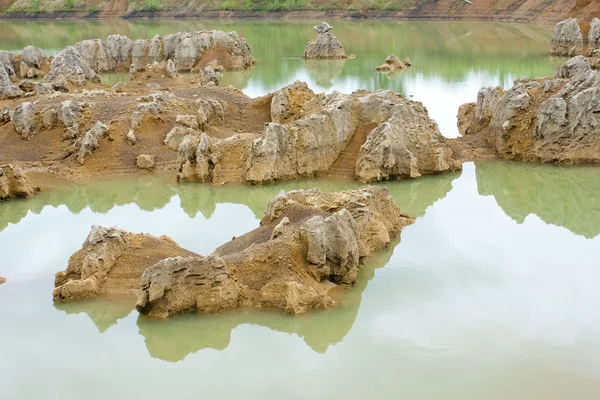 Gröna sjön vatten med lång sten — Stockfoto
